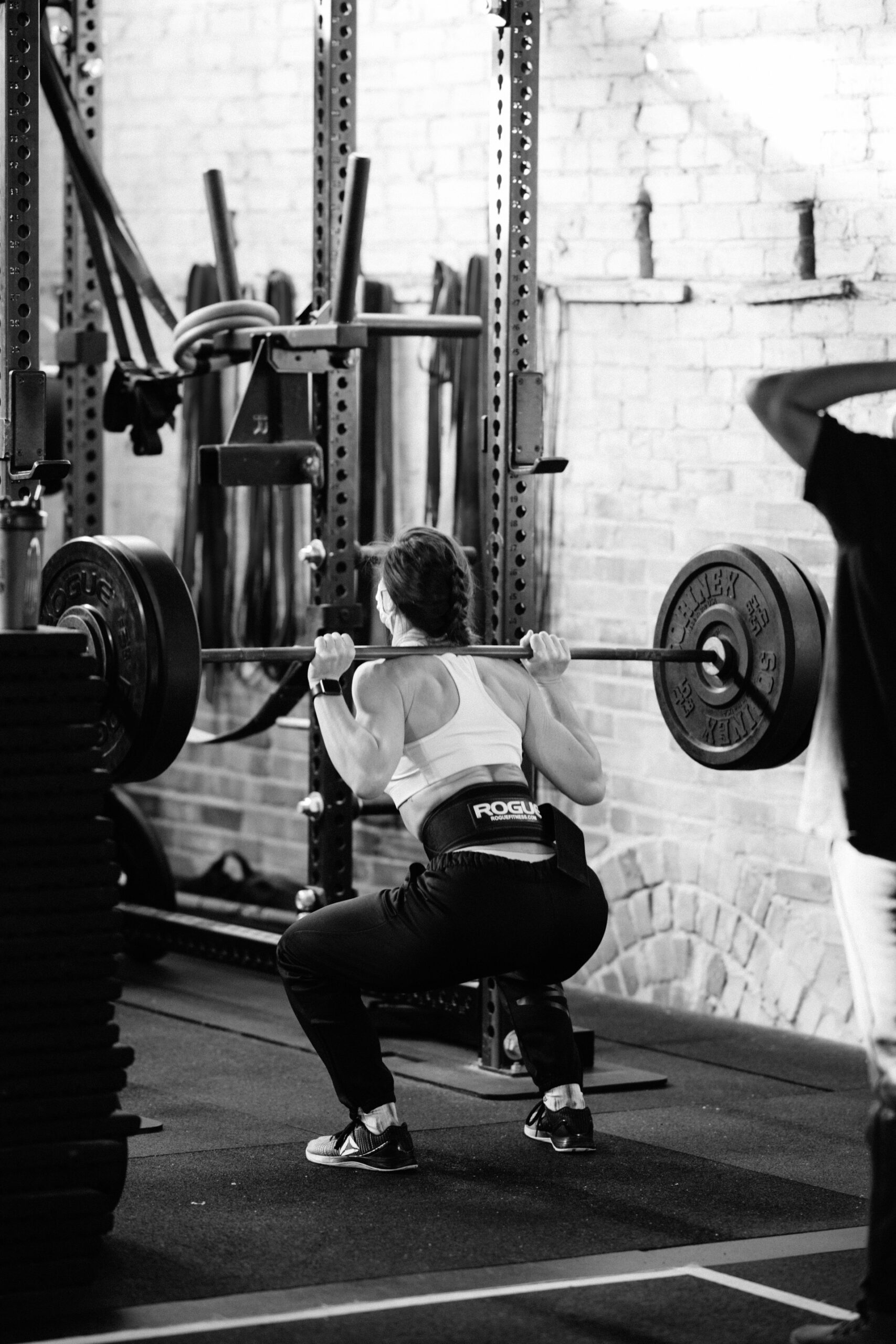 A woman squatting with a barbell